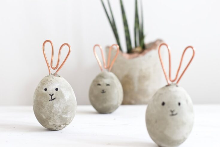 Cute bunny-shaped stones with painted faces and copper wire ears, perfect for charming home decor or Easter decorations, from A Hundred Affections.
