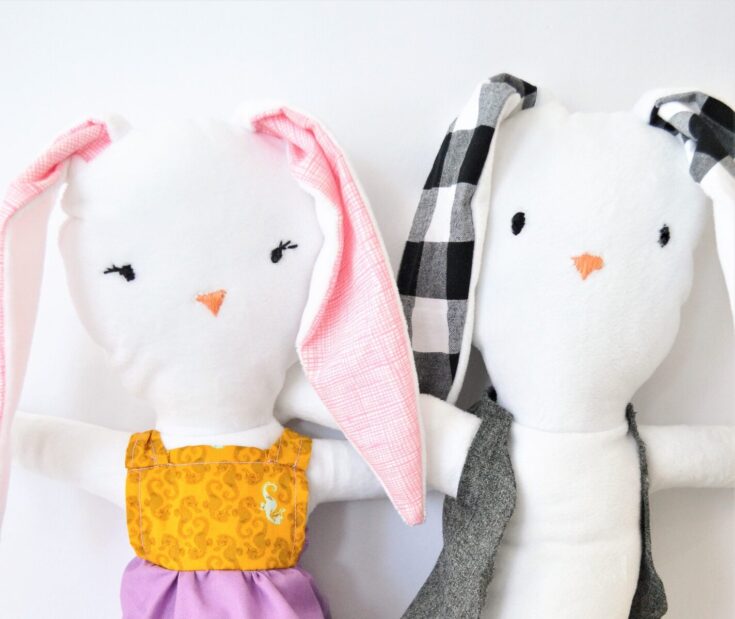 Soft handmade bunny plush toys with embroidered faces and fashionable outfits, ideal for nursery decor or cuddly gifts.
