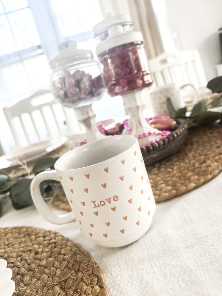 Decorative mug with "Love" and heart pattern, perfect for Valentine's Day or romantic gifts, adds charm to a cozy breakfast or coffee table setting.