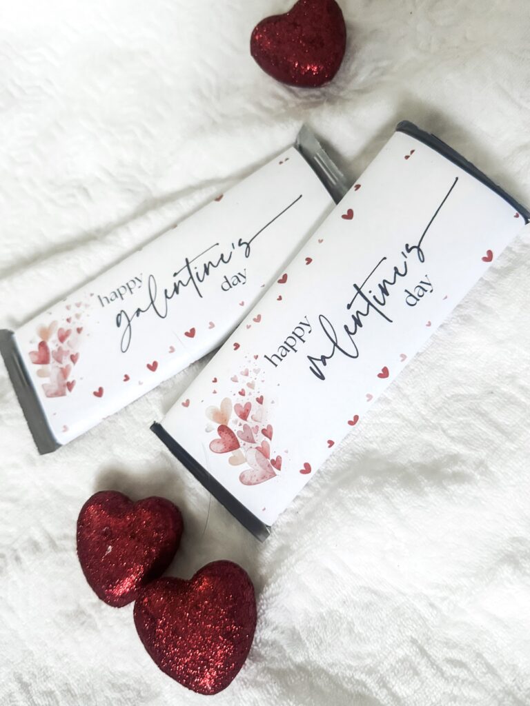 Sweet Valentine's chocolates with "happy valentine's day" printed on elegant packaging, surrounded by glittery red hearts, perfect for romantic gifts and heartfelt celebrations.