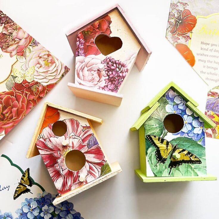 Brightly colored decorative birdhouses featuring floral patterns and butterfly accents, perfect for garden decoration and adding a charming touch to outdoor spaces.