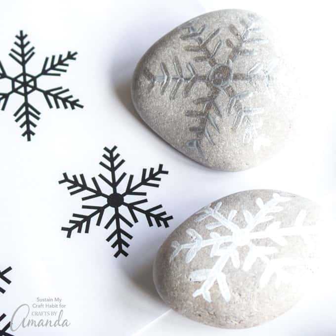 Decorative stones with hand-painted snowflakes for winter decor and crafts. Perfect for seasonal home accents and holiday crafts. Unique, artistic stone embellishments for festive settings.
