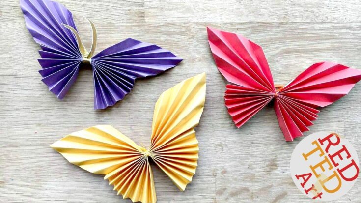 Colorful paper butterfly wall decorations in purple, yellow, and red, ideal for DIY projects, home decor, and celebrations, showcasing vibrant, folding paper craft artistry.