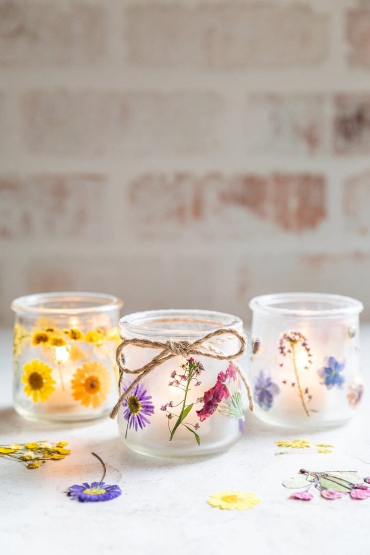 Elegant glass candles decorated with colorful pressed flowers, ideal for spring decor, romantic gifts, or a cozy ambiance.