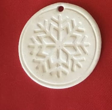 Delicate snowflake-shaped ornament made of white ceramic, perfect for winter-themed crafts, jewelry, or holiday decorations. Beautiful snowflake design suitable for seasonal decor.
