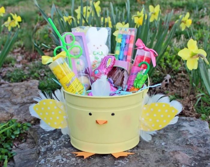 Colorful Easter gift bucket for kids with toys and art supplies, decorated as a cute chick with yellow polka-dot wings, perfect for spring celebrations and Easter surprises.