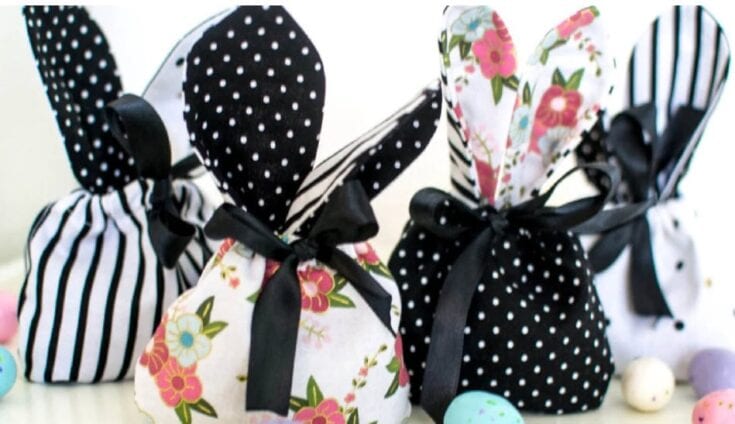 Colorful fabric gift bags with floral, polka dot, and stripe patterns, tied with black satin ribbons, perfect for gifting or party favors.
