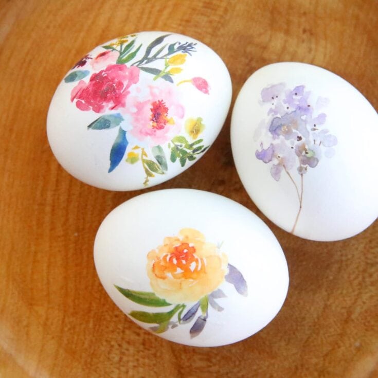 Beautiful decorated stones with watercolor flower designs, perfect for adding charm to garden or indoor spaces, handmade painted floral stones.