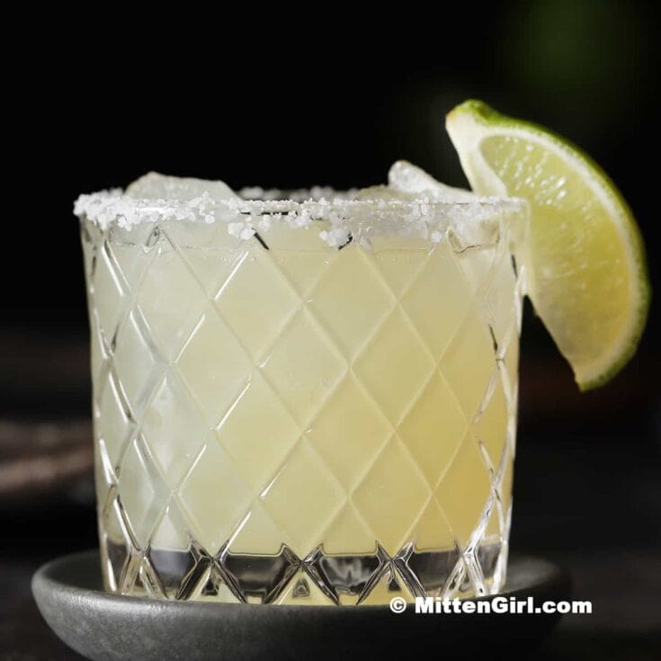 A refreshing lemon margarita served in an elegant glass with salted rim and lime wedge, ideal for cocktails and summer parties.