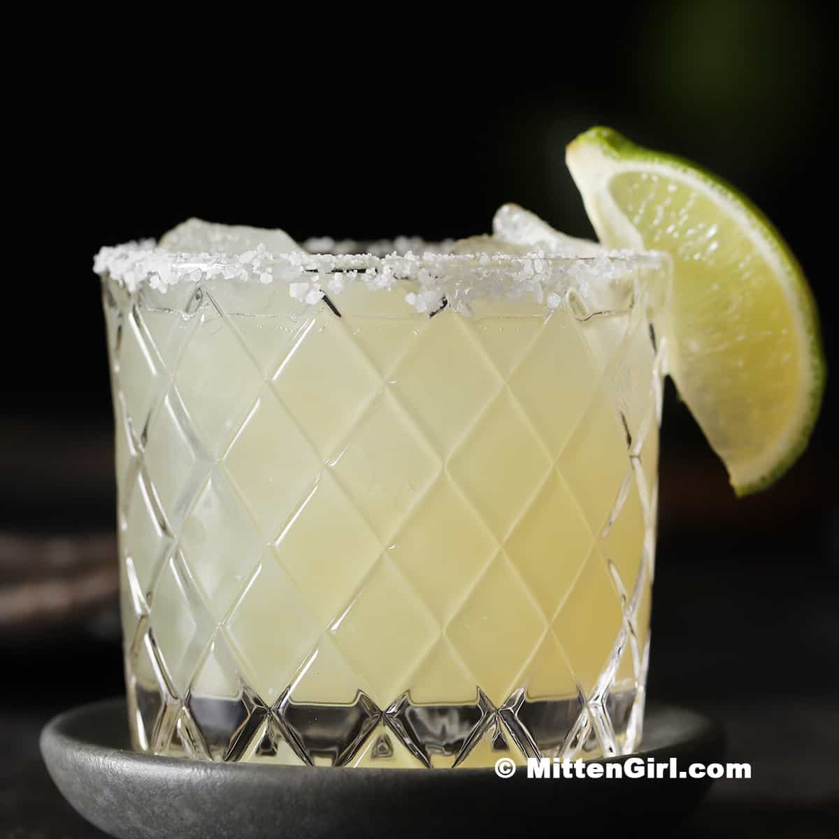A refreshing lemon margarita served in an elegant glass with salted rim and lime wedge, ideal for cocktails and summer parties.