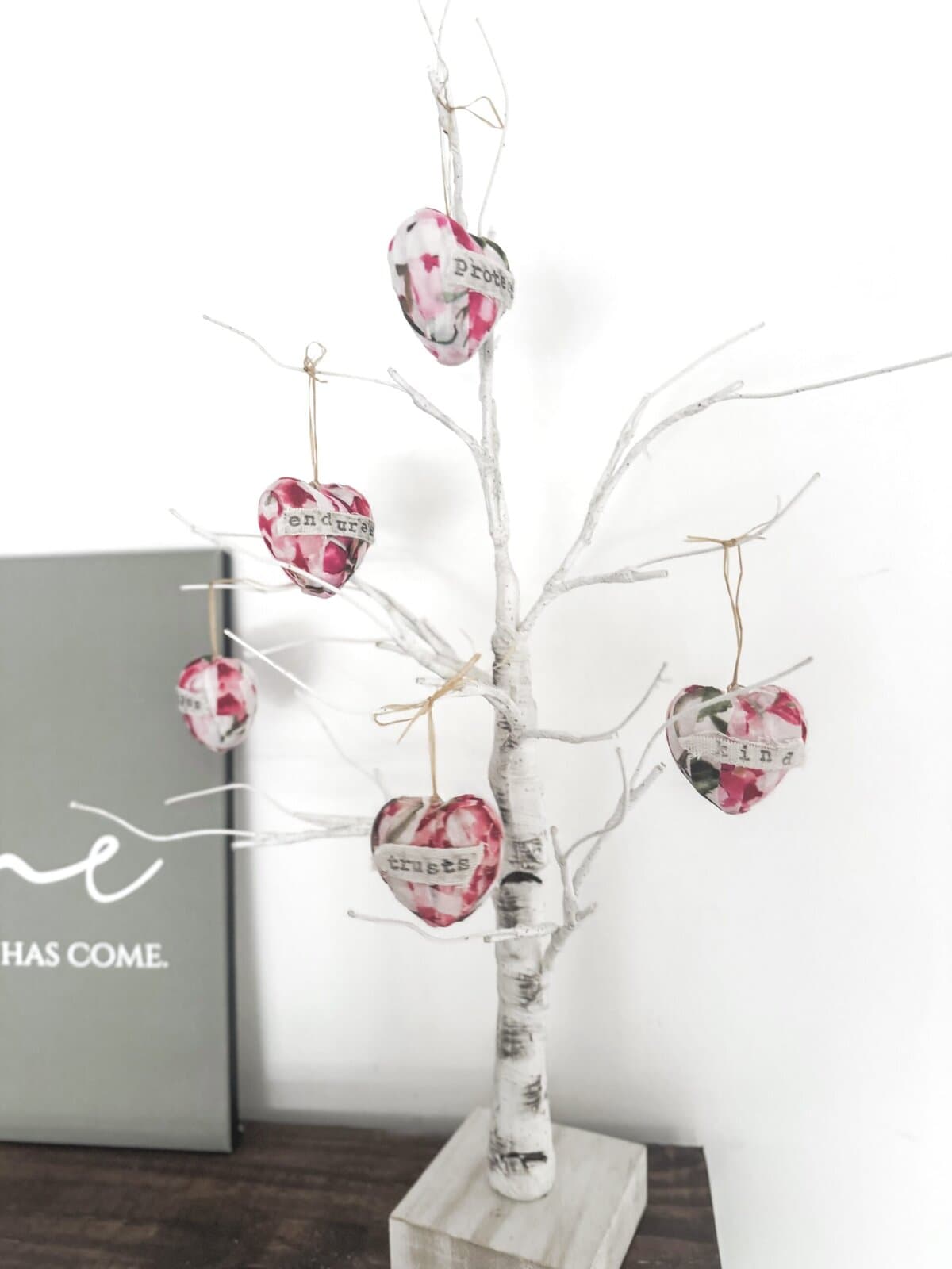 Decorative white tree with hanging fabric hearts, perfect for romantic or wedding-themed decor, symbolizing love and affection.