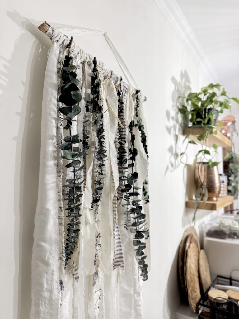 A beautiful eucalyptus garland hanging on a white wall, perfect for enhancing home decor with natural greenery and rustic charm.