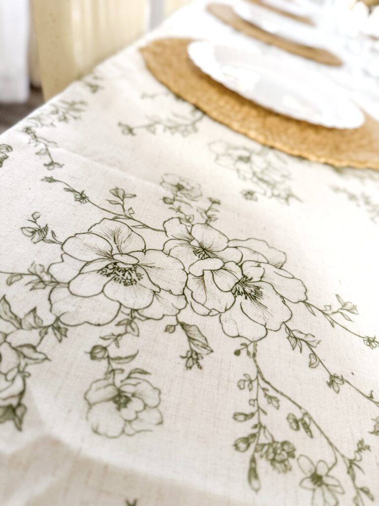 A beautiful embroidered tablecloth featuring delicate floral patterns, perfect for enhancing your dining space with a touch of elegance and charm.