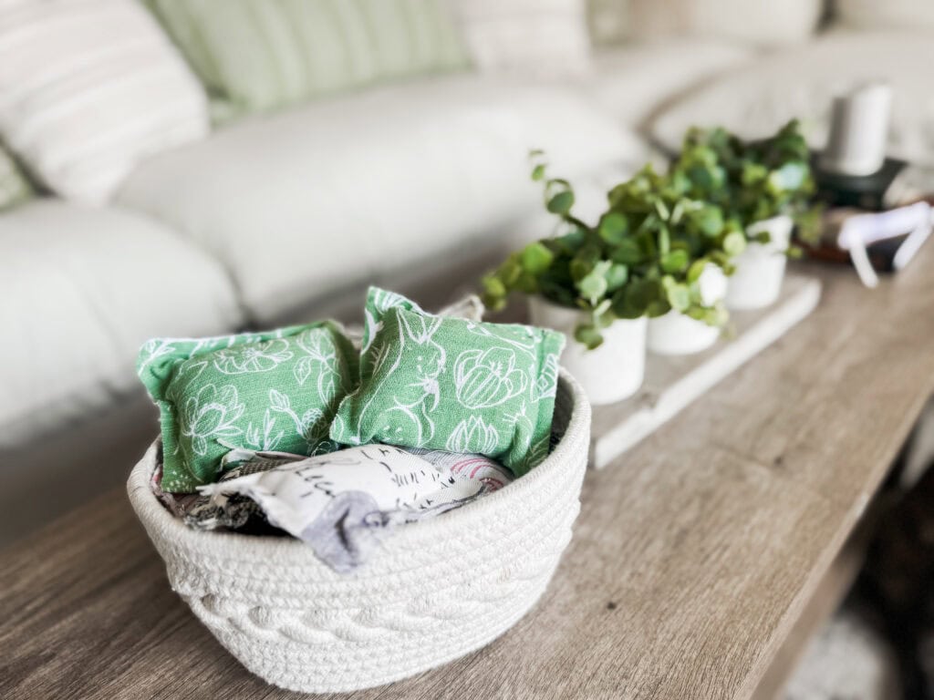 Beautiful green linen sachets with botanical patterns in a white woven basket, perfect for home decor, gift ideas, or freshening up living spaces.