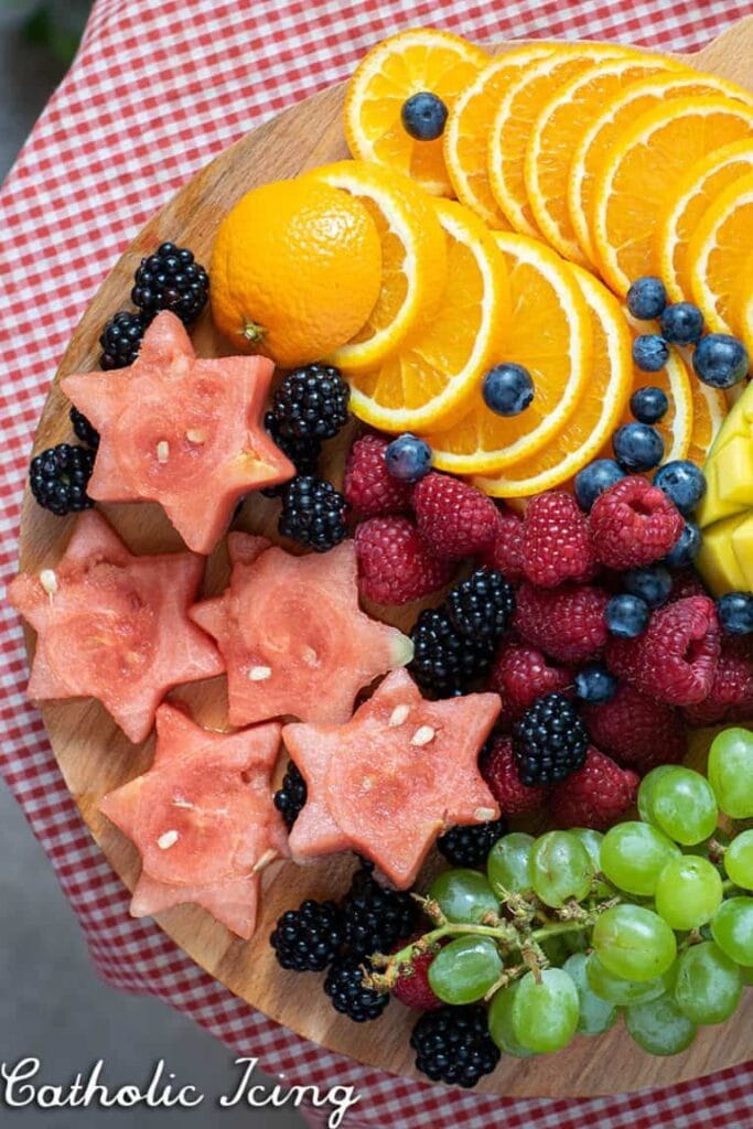 Bright citrus slices, berries, and sweet treats arranged on a wooden platter for a meaningful event.