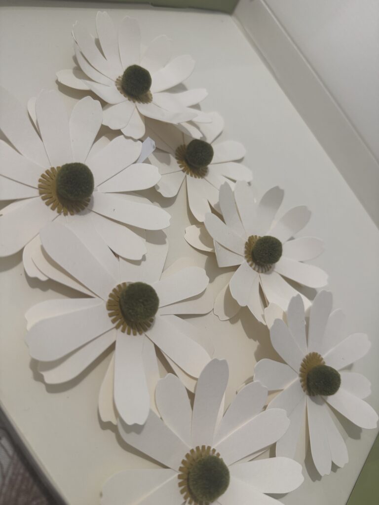 Handcrafted paper daisies with white petals and dark centers, perfect for spring decor or floral arrangements, showcasing delicate and artistic paper flower design.