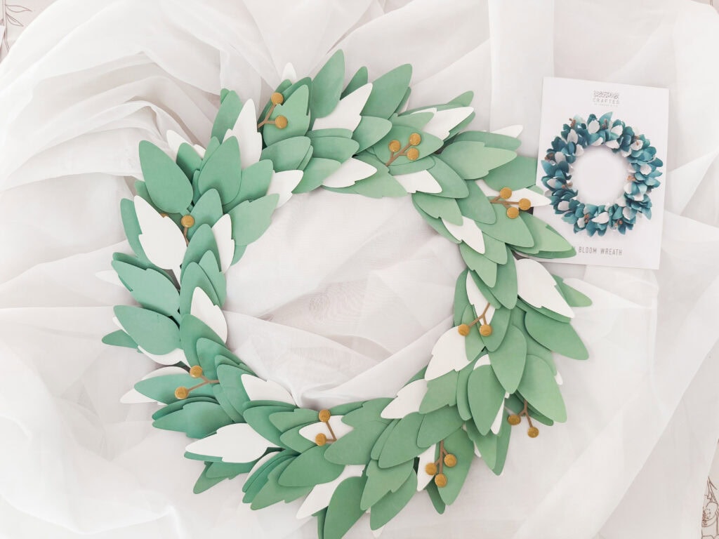 A decorative spring green leaf wreath made of foam leaves with small yellow accents, perfect for enhancing home decor or special occasions.
