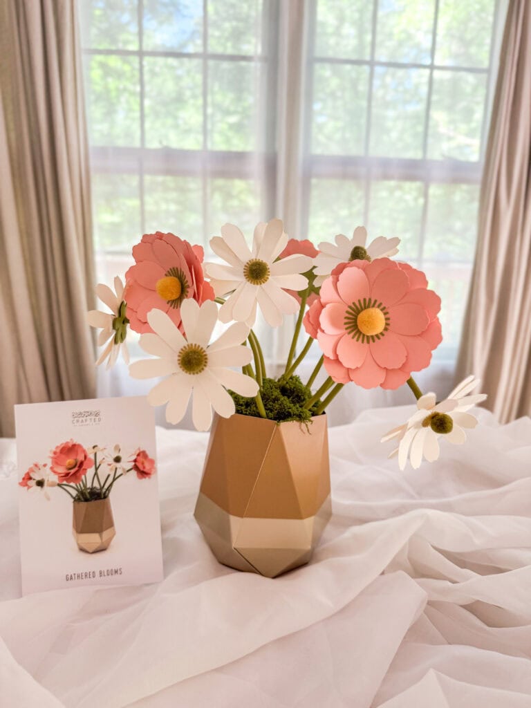A beautiful floral arrangement featuring pink and white paper flowers in a modern geometric vase, perfect for home decoration and adding a touch of elegance to any space.