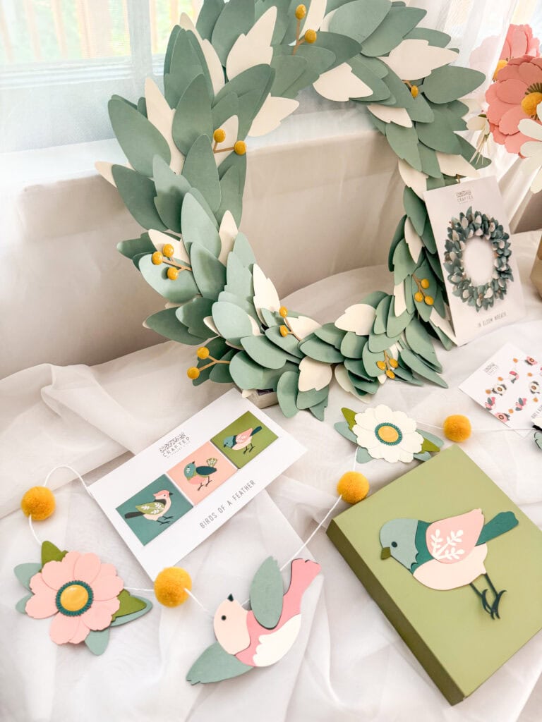 Beautiful handcrafted paper flower wreath and matching decor, perfect for spring celebrations and home decor, featuring pastel colors and delicate floral designs.