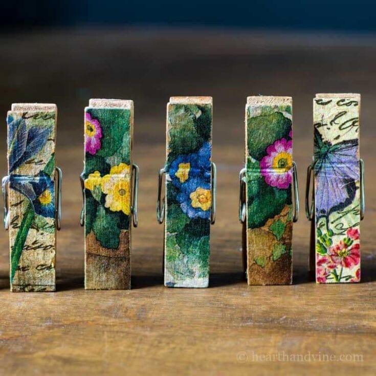 Colorful floral fabric clothespins with butterfly and handwritten script designs, perfect for decorative crafts and gift wrapping.