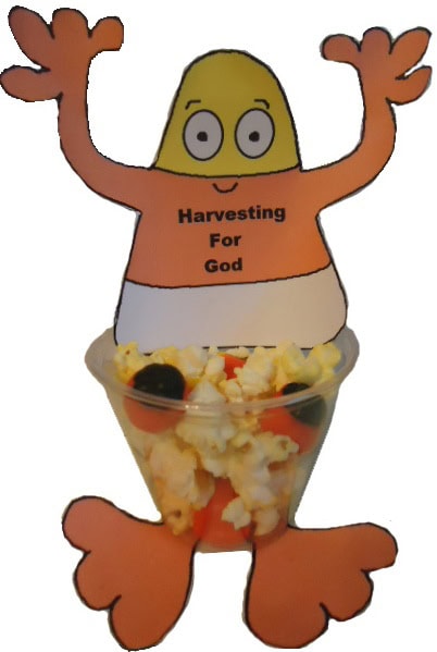 Cute Easter egg character with arms raised, wearing an orange shirt with 'Harvesting For God' text, sitting in a bowl of popcorn, representing a festive and religious theme.