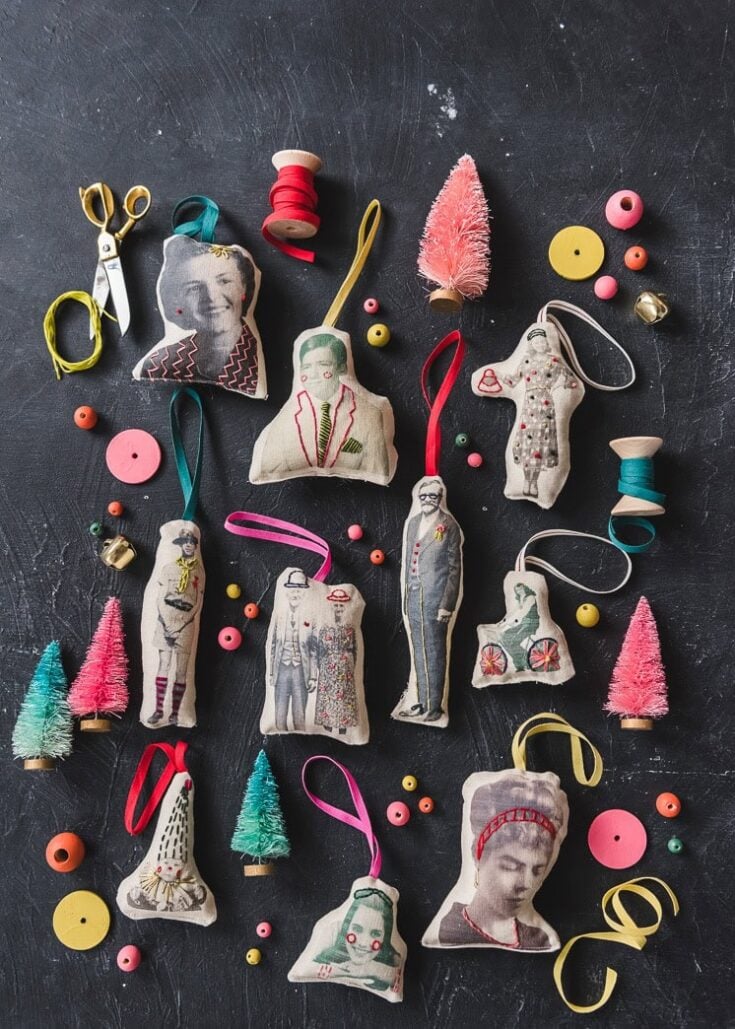 Assorted vintage fabric ornaments, miniature trees, buttons, and sewing accessories arranged on a dark surface for craft decoration and DIY projects.