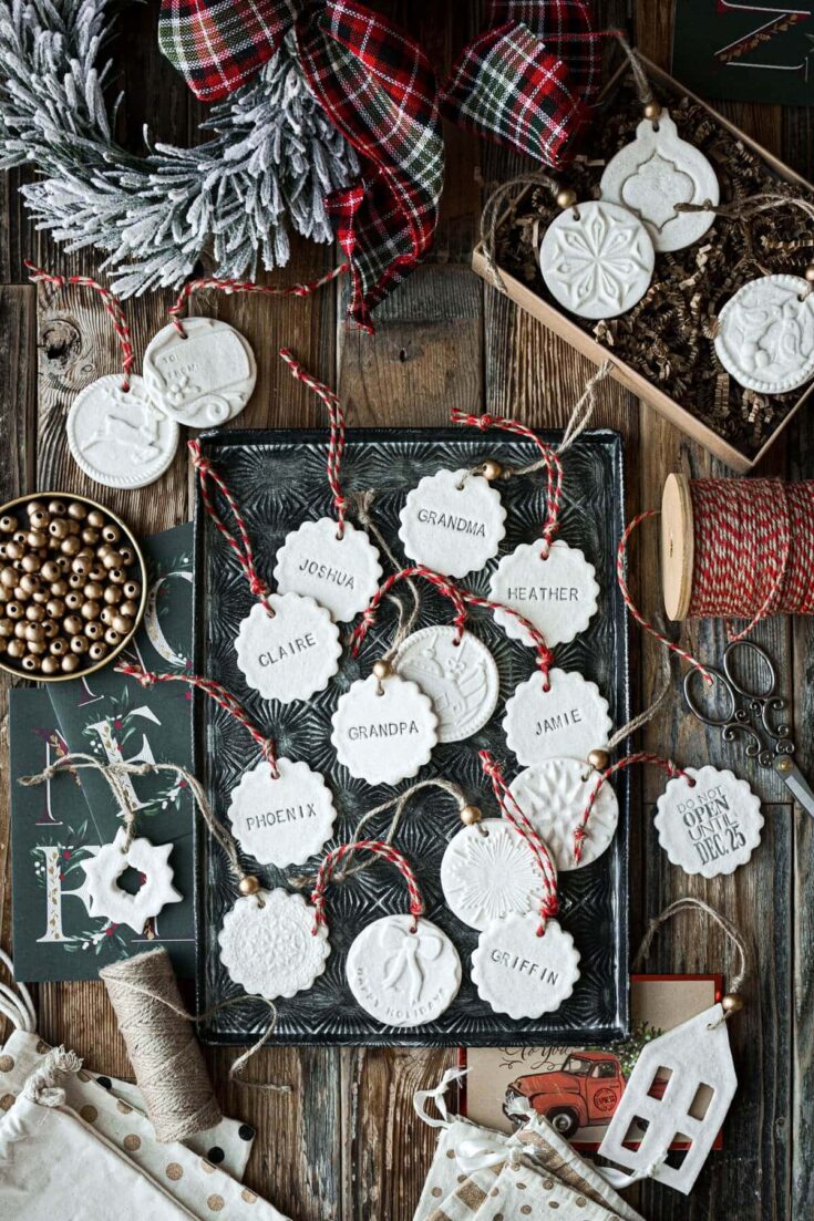 Handmade Christmas gift tags with family member names, featuring festive designs and red and white twine, perfect for holiday gift wrapping and personal touches.