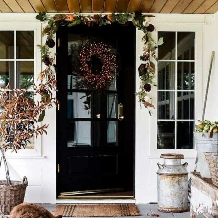 Charming fall-themed front door decorated with a wreath and autumn foliage, perfect for cozy seasonal home decor ideas.