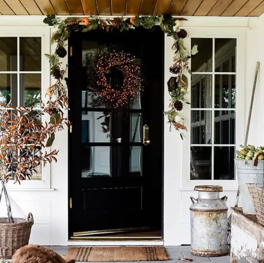 Charming fall-themed front door decorated with a wreath and autumn foliage, perfect for cozy seasonal home decor ideas.