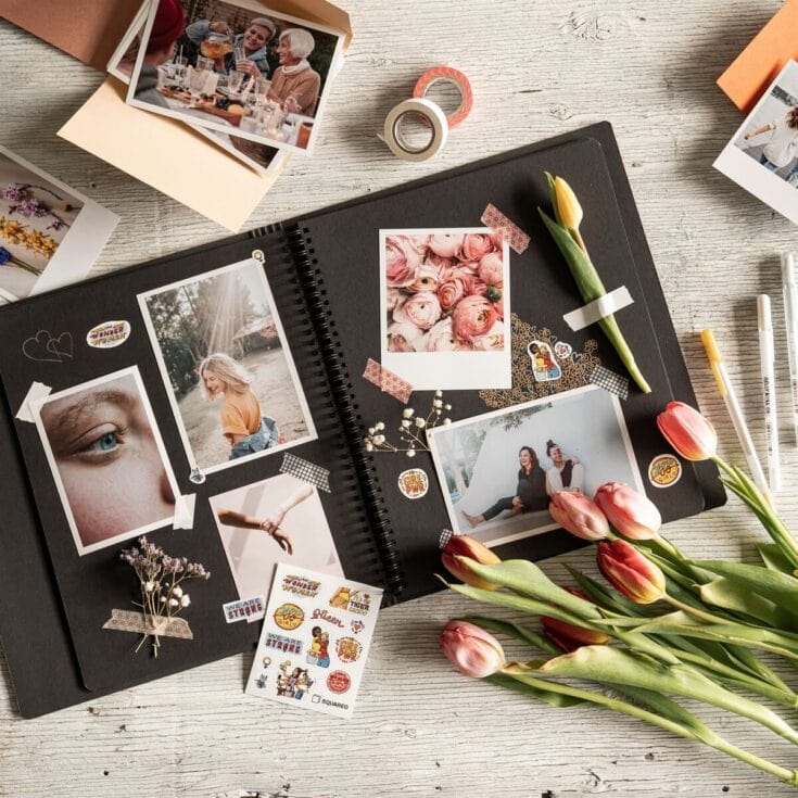 A photo album open on a table with printed photos, flowers, and decorative stickers, capturing cherished memories and moments of love and friendship.