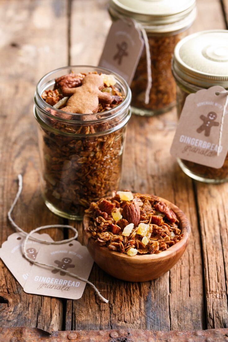 Homemade gingerbread cookie mix in glass jars with tags, perfect for DIY Christmas gifts, on rustic wooden background, ideal for budget-friendly holiday presents.