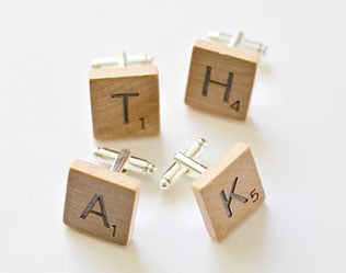 Four wooden Scrabble blocks with letters T, H, A, and K arranged on a white background, symbolizing words and creativity for home decor or educational purposes.