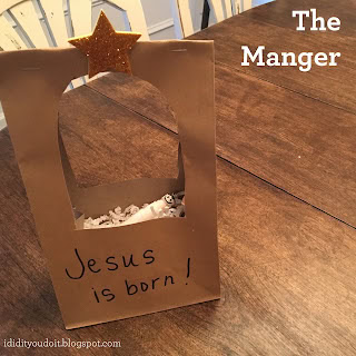 Handmade wooden manger scene with a star on top and a small figure inside, symbolizing the birth of Jesus Christ for Christmas celebration.