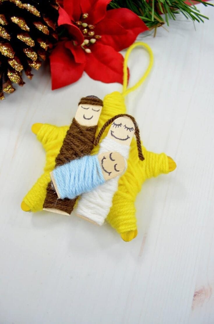 Three handmade felt Christmas ornaments depicting Mary, Joseph, and baby Jesus, with festive holiday decorations in the background, perfect for holiday decor.