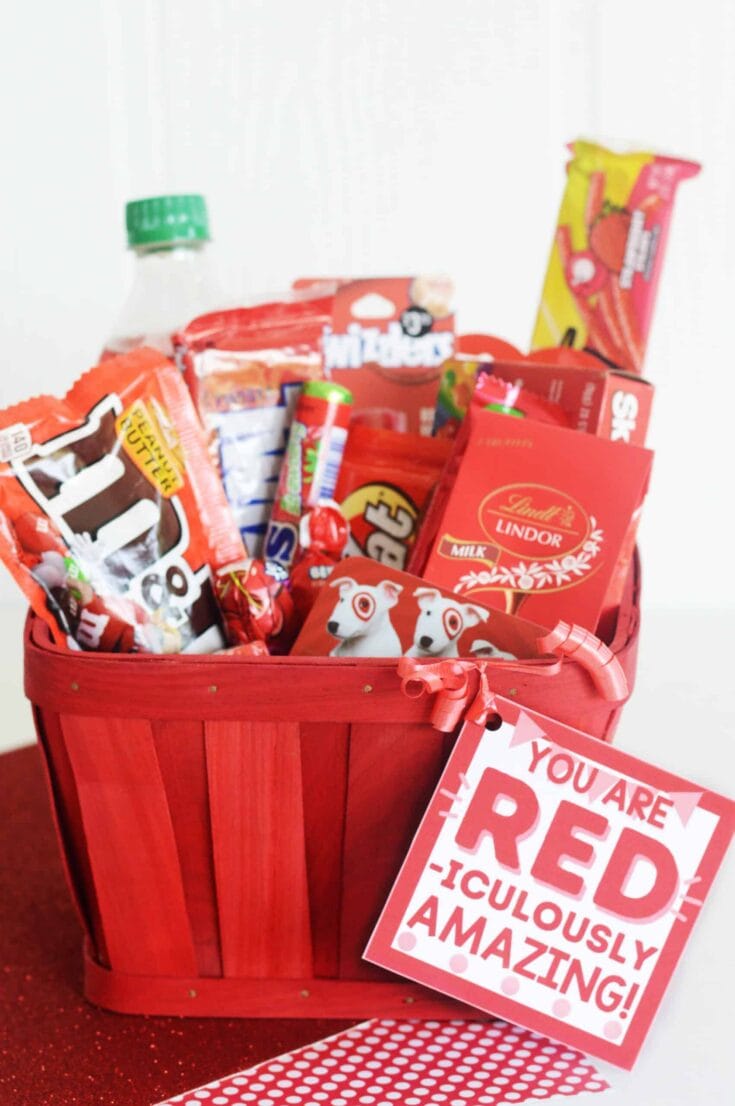 Red gift basket filled with assorted candies, chocolates, and snacks for Valentine's Day, with a tag reading 'You are RED! I-culously Amazing!'.