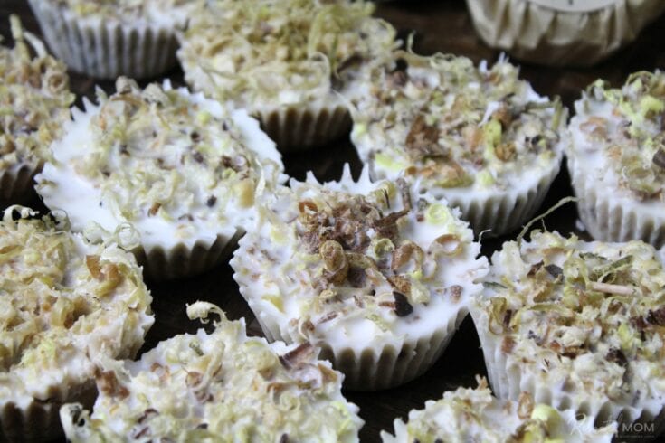 Close-up of decorative cupcakes with white icing, shredded toppings, and sprinkles, perfect for celebrations or dessert tables.