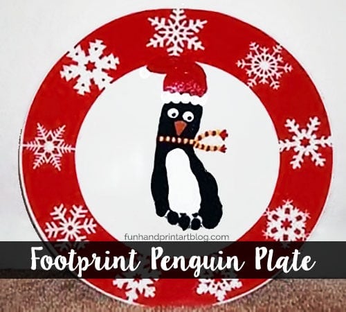 Decorative Christmas plate featuring a footprint penguin wearing a Santa hat, surrounded by snowflakes, perfect for holiday table settings and festive decor.