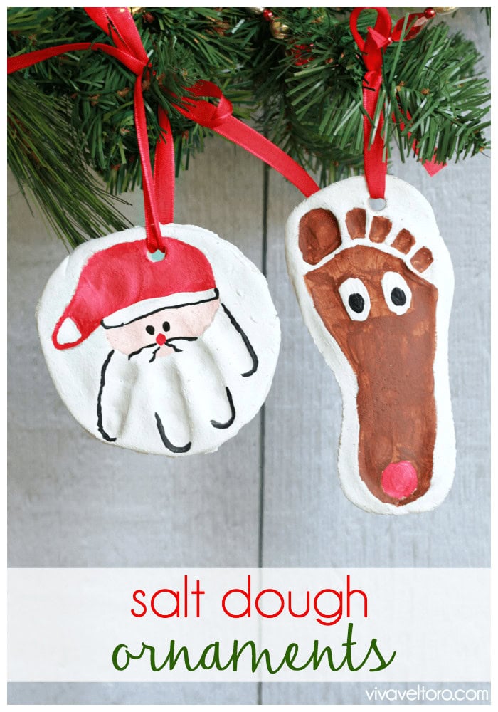 Handmade salt dough Christmas ornaments featuring a Santa face and a reindeer hoof, hanging on a decorated Christmas tree with red ribbons.