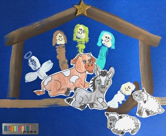 Colorful felt nativity scene featuring a cow, donkey, sheep, and angel figures on a blue background, with a wooden stable and star decoration, for Christmas decor.