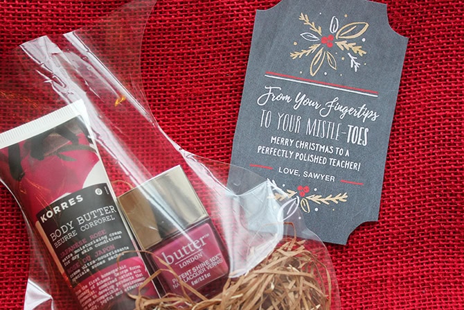 A holiday gift set featuring Korres body butter and a festive Christmas tag on a red textured background, perfect for holiday gifting and skincare.