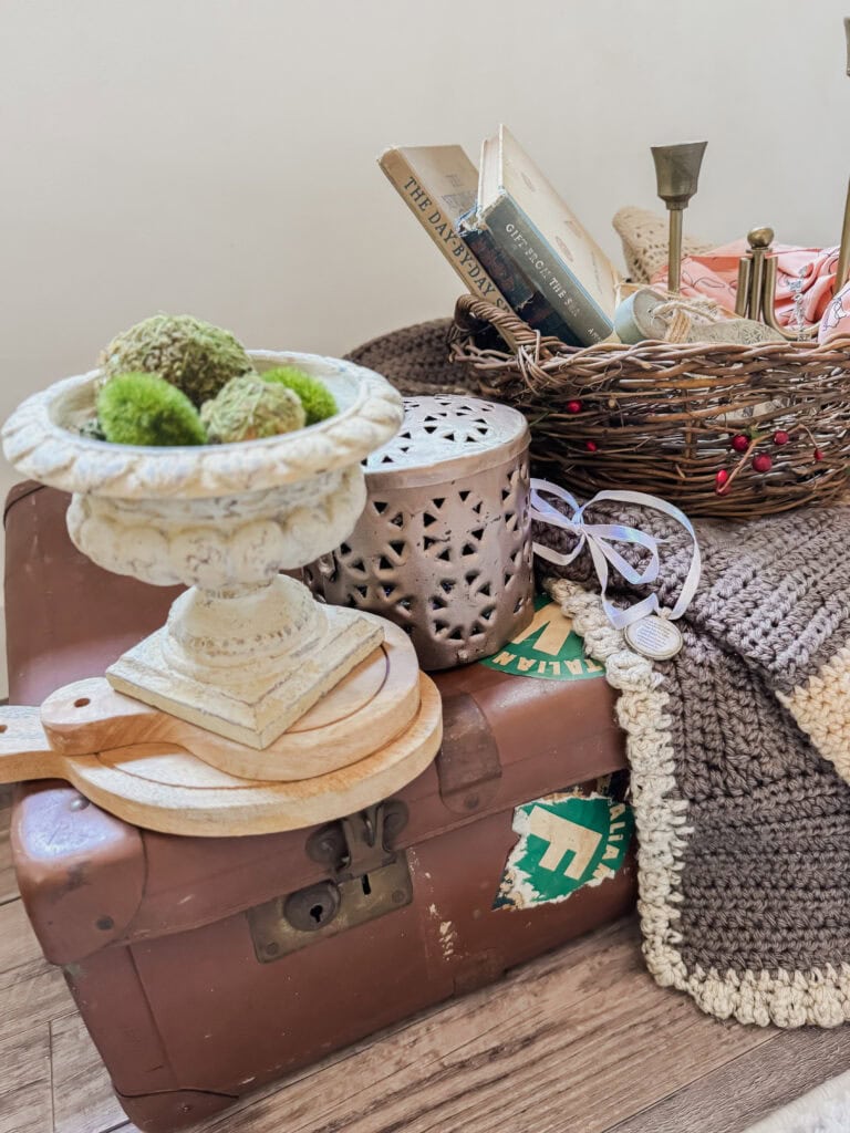 Decorative vintage travel trunk with books, candles, and cozy blanket, creating a warm and nostalgic home decor scene.