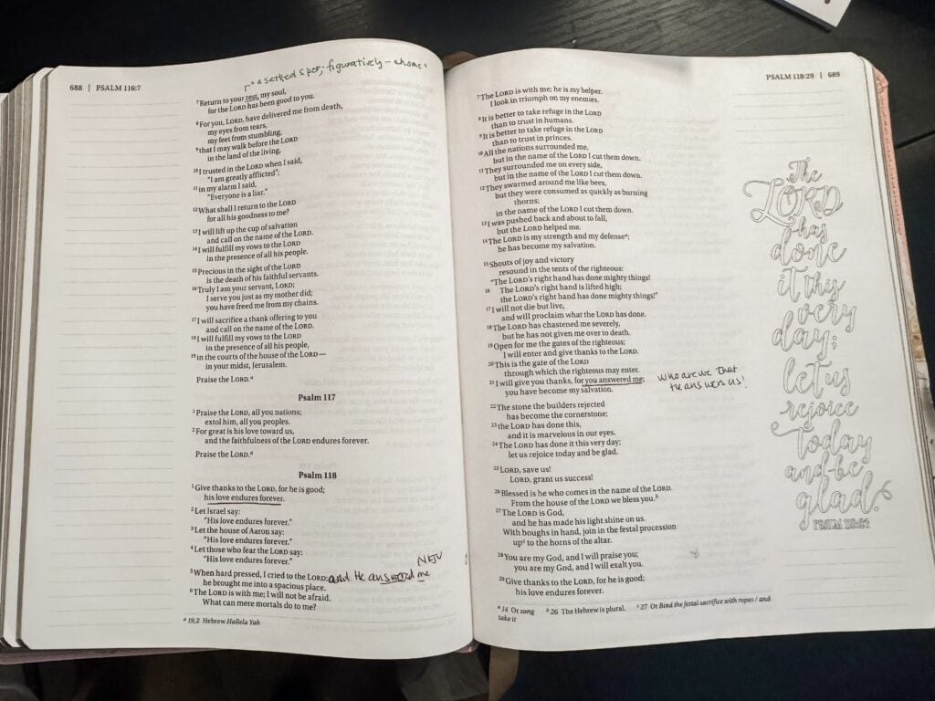 Open Bible with handwritten notes, underlines, and highlights on Psalm 117 and 118 pages, featuring a decorative quote on the right page, for spiritual reflection and study.