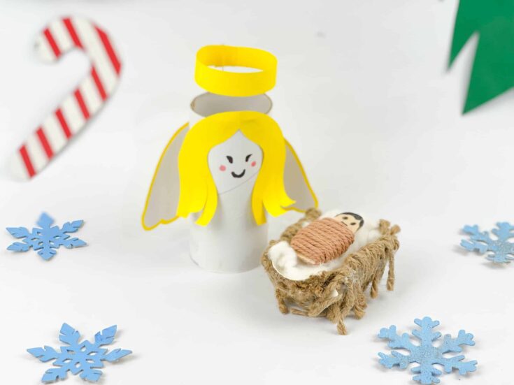 Cute handmade Christmas nativity scene with paper angel, plush manger, and snowflake decorations for holiday decor.