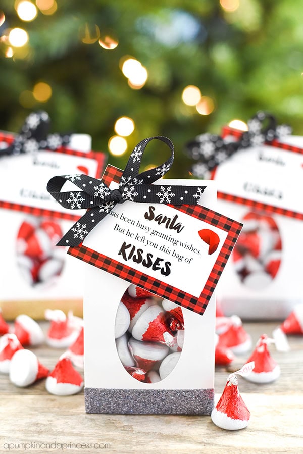 Festive Christmas candy favors in white boxes with Santa tags, red and white candies, and holiday decorations, perfect for holiday gifting and celebrations.