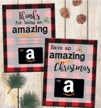 Two printable Christmas cards with a red and black plaid background, featuring messages of appreciation for teachers and Amazon gift card images, on a wooden surface with pinecones and greenery.