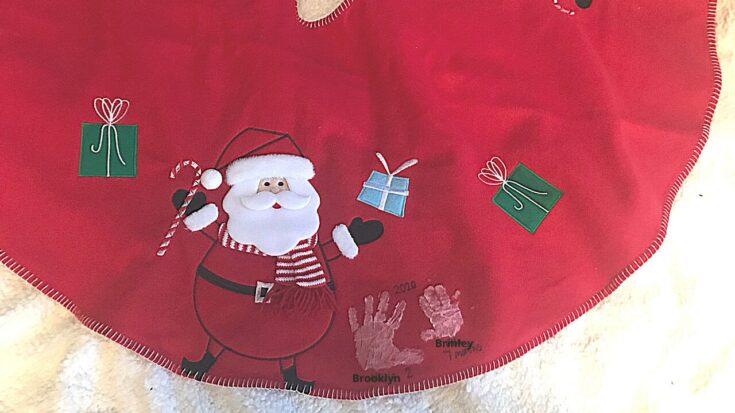 Festive red cloth featuring Santa Claus holding a gift, surrounded by colorful wrapped presents, perfect for holiday decor and Christmas celebrations.