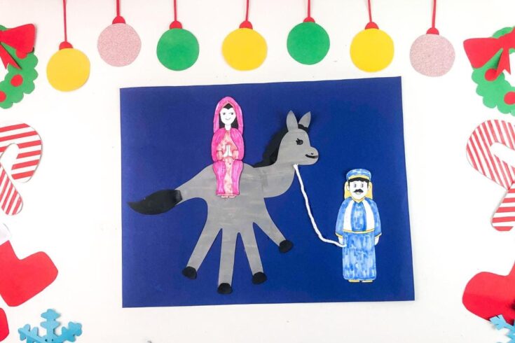 Colorful holiday craft featuring paper dolls of a girl riding a donkey and a man, surrounded by Christmas decorations like stockings, candy canes, and ornaments.