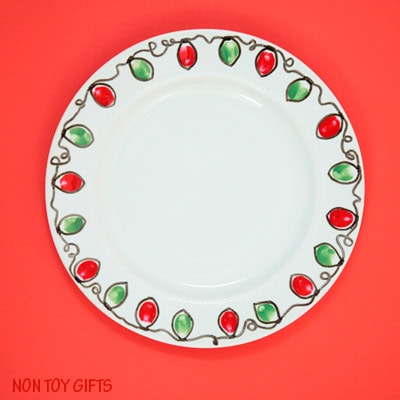 Decorative ceramic plate with a festive red and green light bulb pattern around the rim, perfect for holiday table settings or gift-giving.