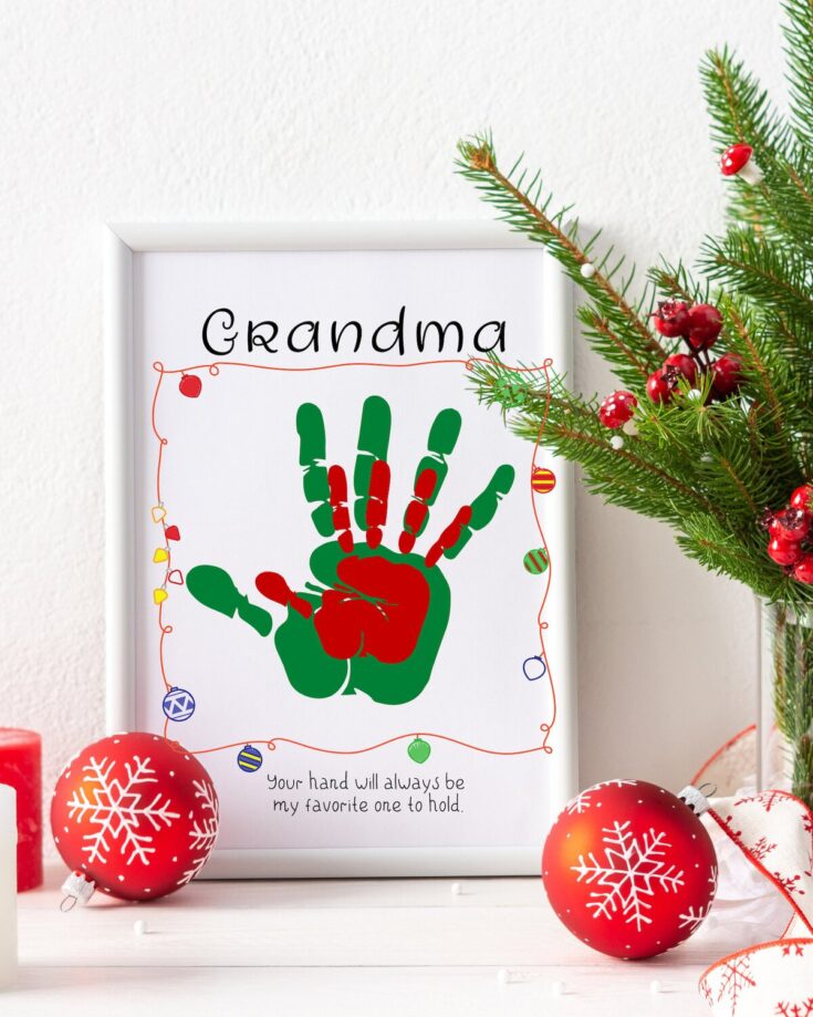 Festive Christmas decoration with a framed handprint art titled Grandma, surrounded by red ornaments and a Christmas tree branch, perfect for holiday gifts.