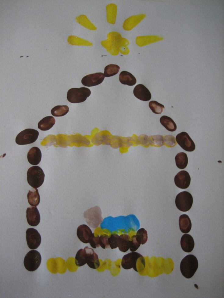Colorful child's drawing of a house with a yellow sun, blue sky, and brown walls, created with paint and coffee beans on white paper.